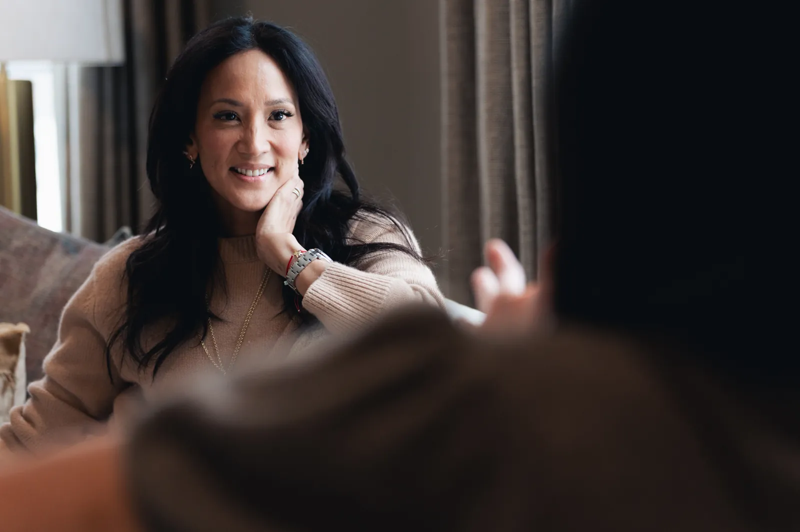 Dr. Valerie Woo smiling in conversation in a living room