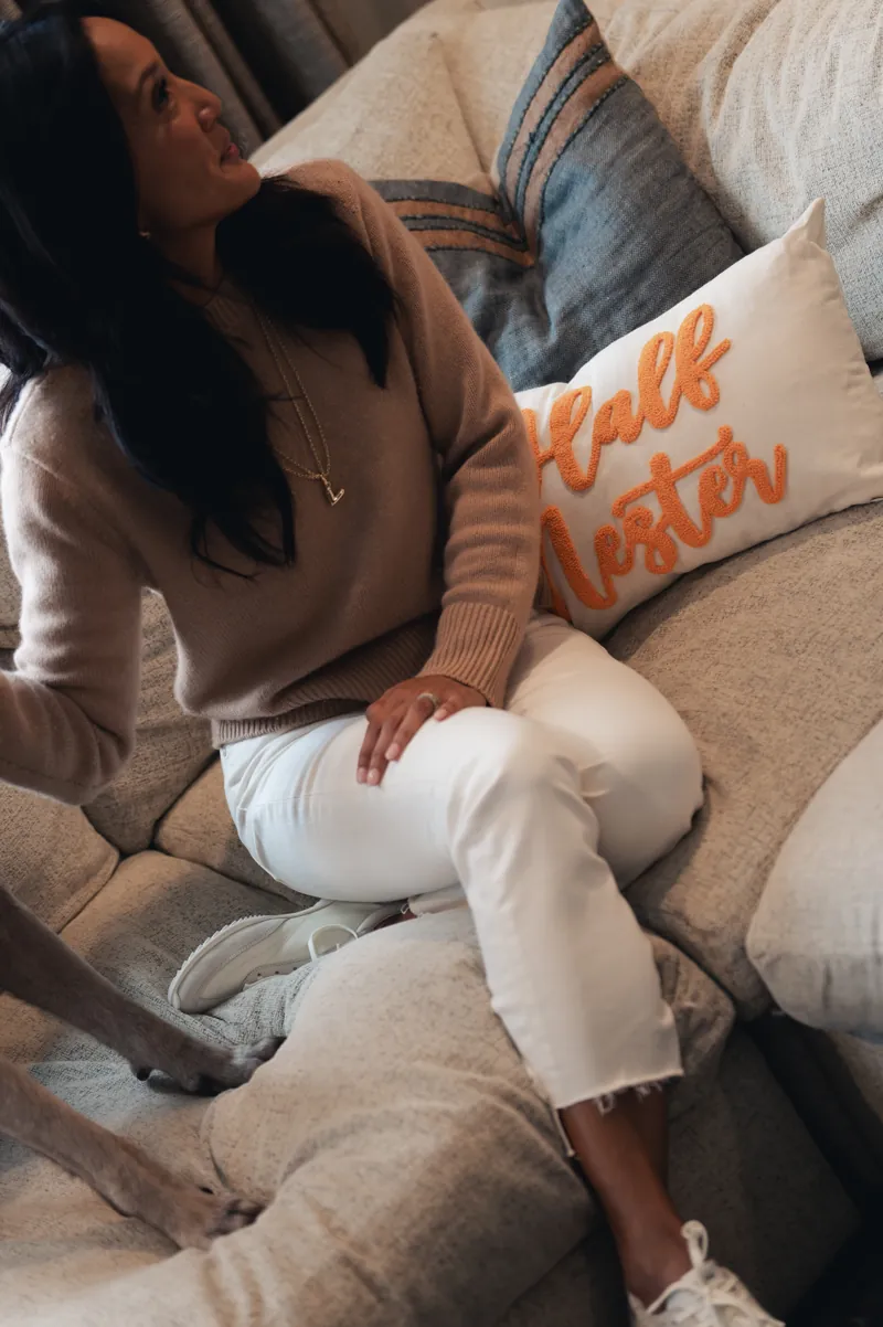 Dr. Valerie Woo sitting on a sofa beside a Half Nester pillow