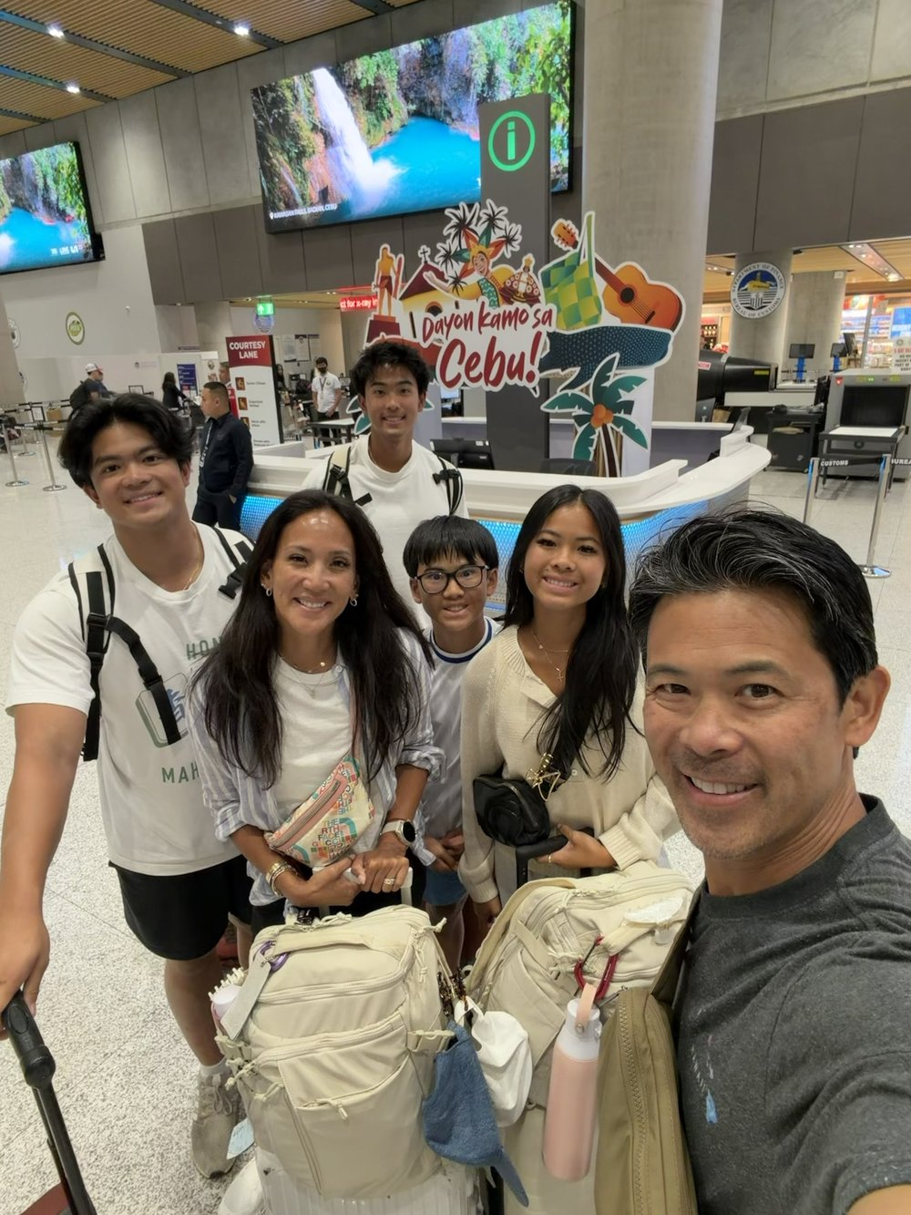 Dr. Valerie Woo and her family arriving at Cebu airport beneath a “Dayon kamo sa Cebu” welcome sign