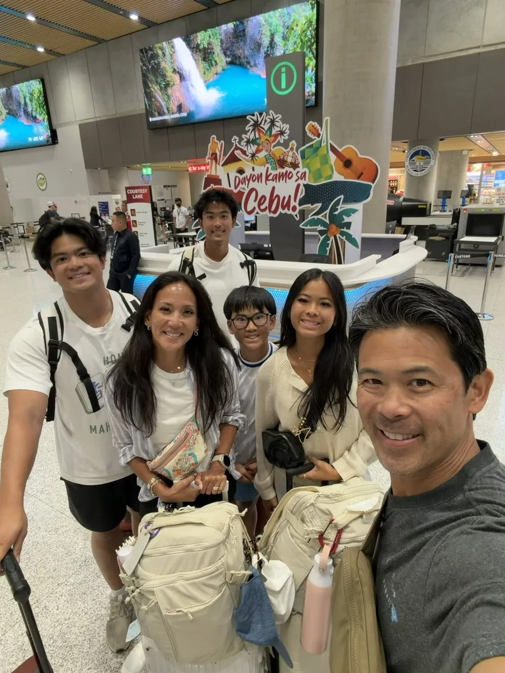 Dr. Valerie Woo and her family arriving at Cebu airport beneath a “Dayon kamo sa Cebu” welcome sign
